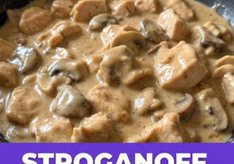 Stroganoff di pollo cremoso con funghi in padella di ghisa, servito su riso basmati, fotografato dall'alto su tavolo in legno rustico